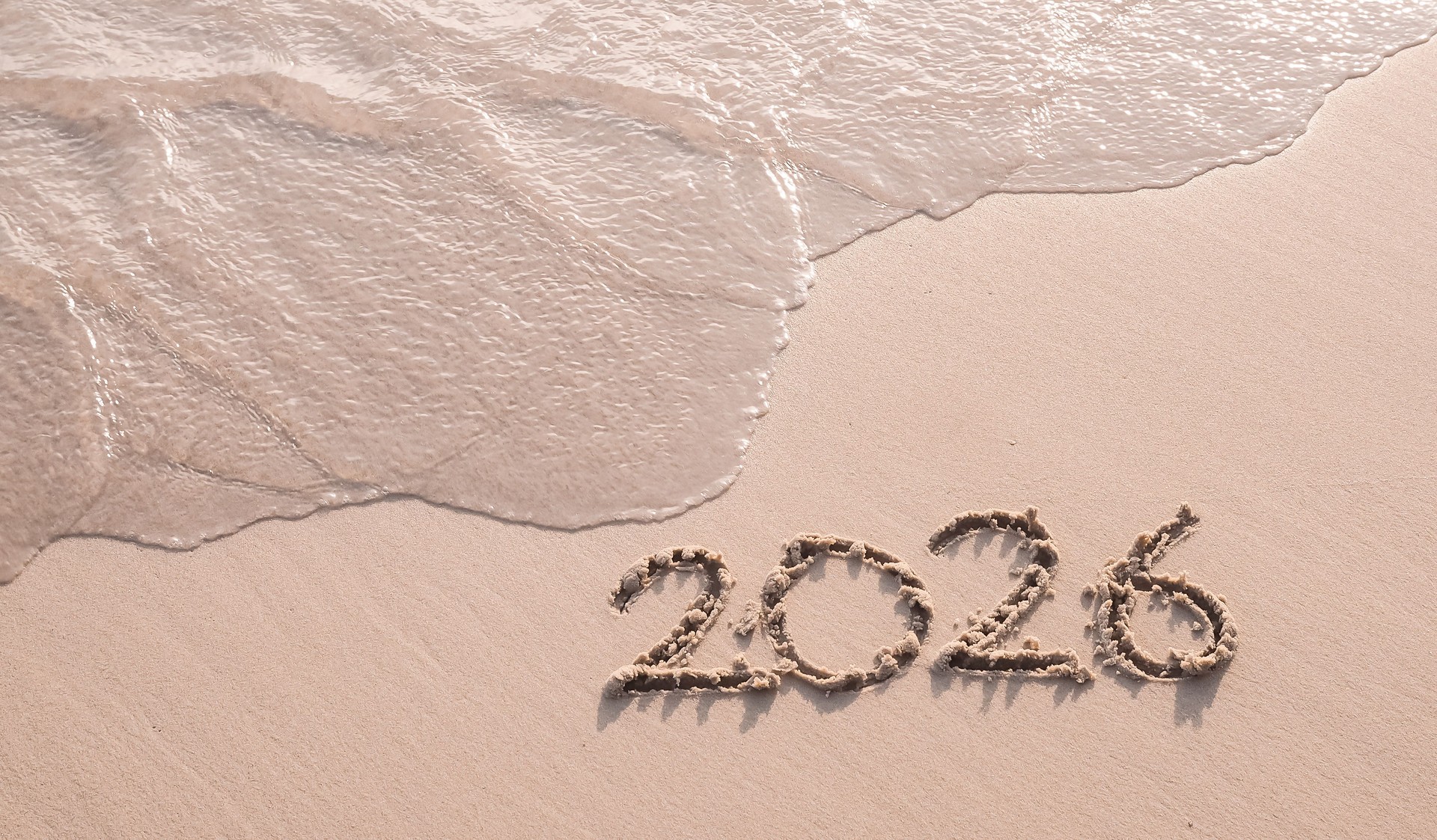 2026 year handwritten on the beach in the sunset time. New Year 2026 concept